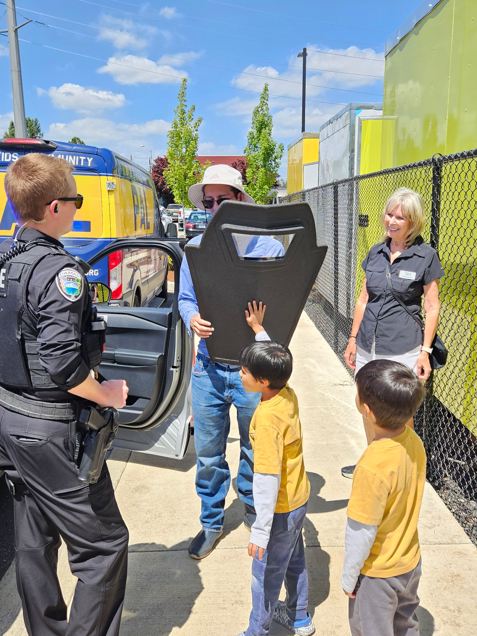 Children learning about a police shield from a Camas police officer